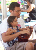 picture of young father with child and ukulele on lap